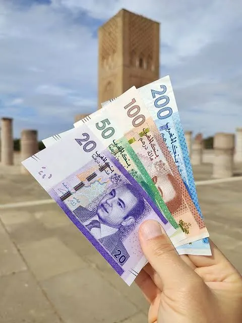 Budget Maroc : billets de dirhams devant la tour Hassan à Rabat Budget Maroc : billets de dirhams devant la tour Hassan à Rabat