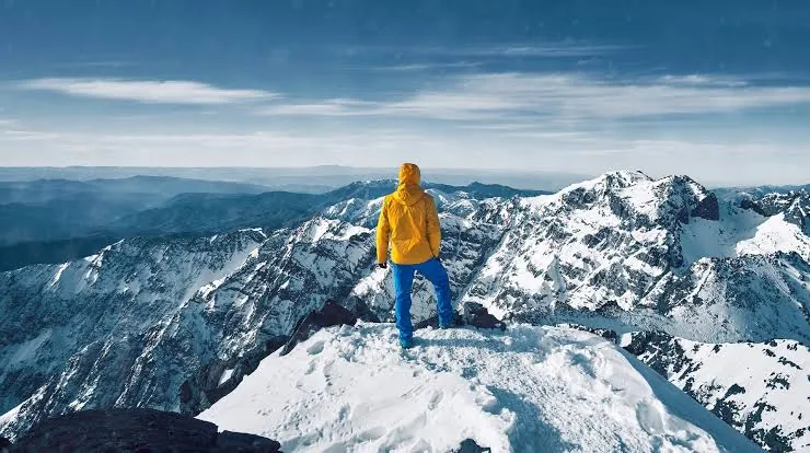 Maroc en hiver : un randonneur sur un sommet enneigé du Haut Atlas