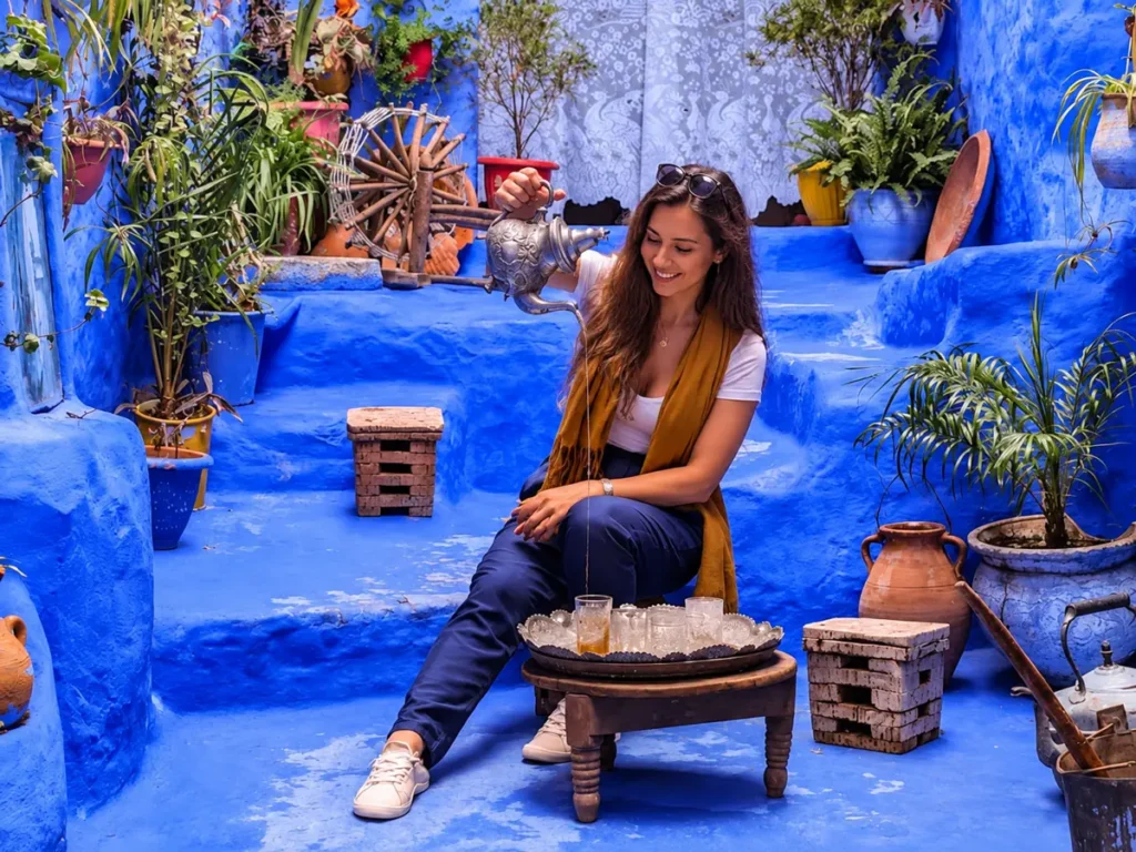 Voyageuse assise sur des marches bleues à Chefchaouen